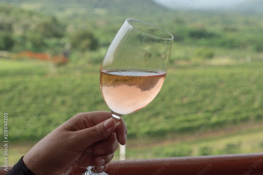 Female hand hold a tilt wine glass in a grape farm Stock Photo | Adobe Stock