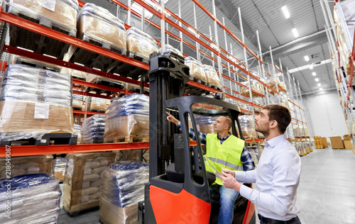 Fotografie logistic business, shipment and people concept - warehouse worker and businessma