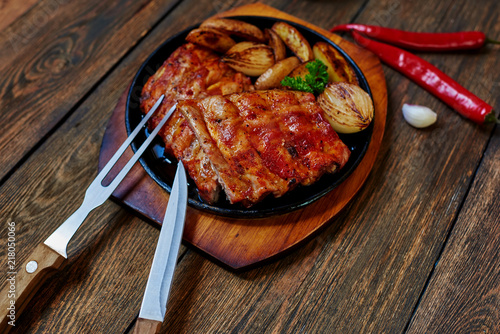 Housewife cook for dinner lamb ribs with vegetables, lies next to a sharp pepper and garlic of which will make the sauce for meat photo