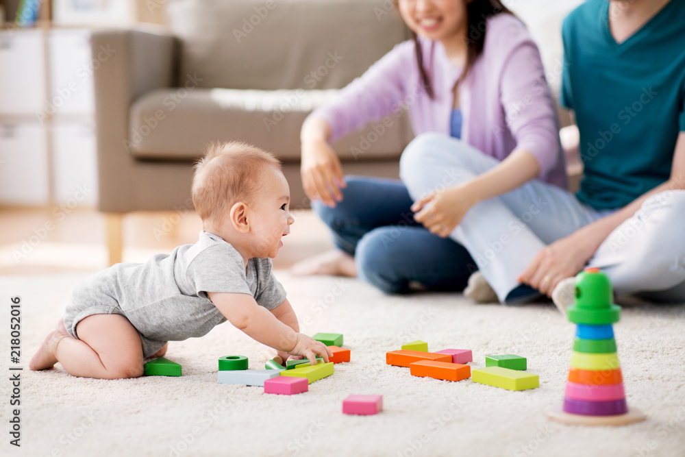 family, parenthood and people concept - happy mother, father and baby boy playing toy blocks at home family, parenthood and people concept - happy mother, father and baby boy playing toy blocks at home