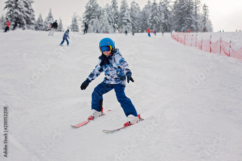 Cute preschool child, skiing in Austrian winter resort on a clear day
