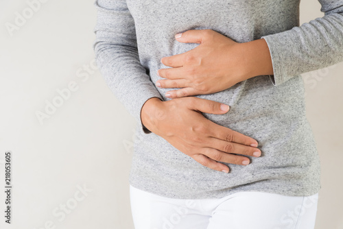 Young woman having painful stomachache. Chronic gastritis. Abdomen bloating concept. photo