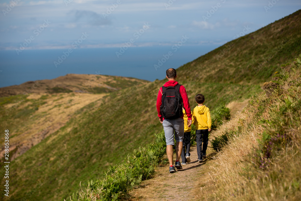 Father and sons, hiking in a beautiful nature of North Devon on a sunny day