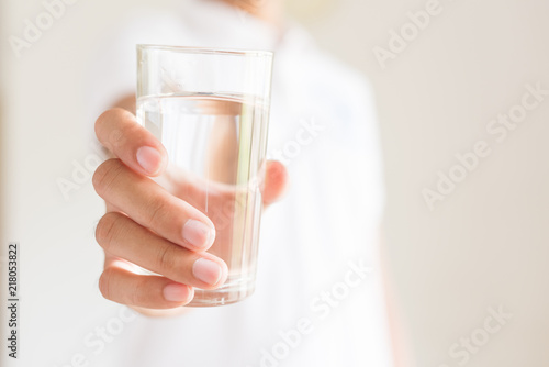 A glass of clean mineral water in man's hands. Concept of environment protection, healthy drink.