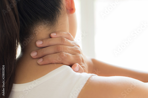 Tela Closeup woman neck and shoulder pain and injury