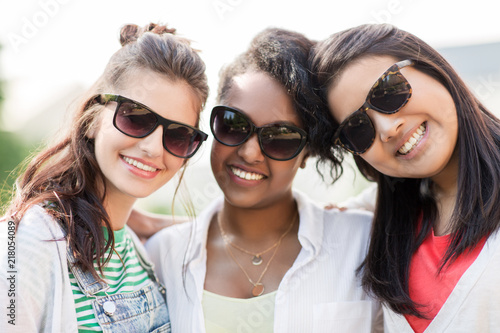 female friendship, summer and eyewear - happy young women in sunglasses outdoors