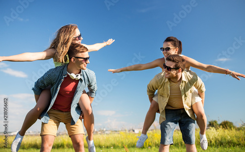 leisure, people and friendship concept - happy teenage friends having fun outdoors in summer