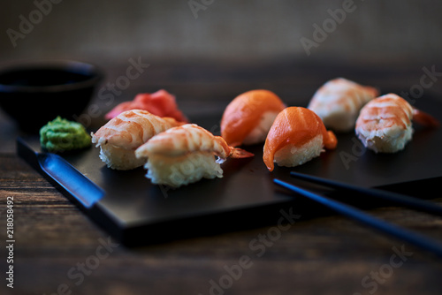 Plate of sushi rolls. Sushi set sashimi and sushi rolls served on wooden plate. Sushi rolls with salmon, eel, tuna, avocado, royal prawn, cream cheese caviar tobica, chuka. Sushi menu. Japanese food.