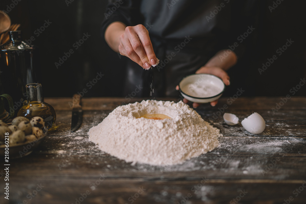 Fototapeta premium Steps of making cooking pie with ingridients. Mixing ingredients: flour, eggs, oil. See series. Step by step recipe. Cooking course or kitchen mess. Female hands make dough for biscuit or pie.