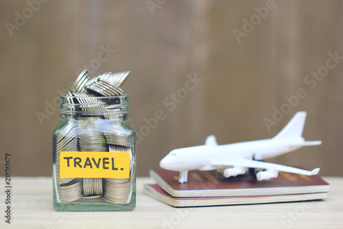 Saving planning for Travel budget of holiday concept,Financial,Stack of coins money in the glass bottle and airplane on passport photo