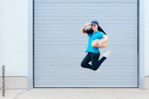Female Delivery Worker Jumping in front of a Storage Warehouse