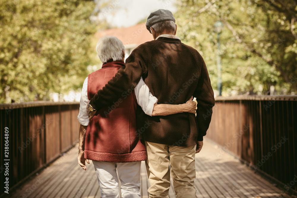 Senior couple walking through a park