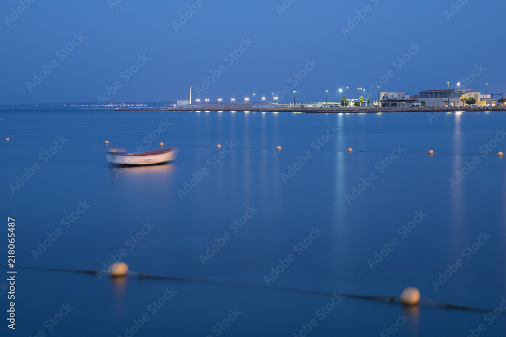 beautiful lights of the city at sunrise with a blue light on the water and the sky