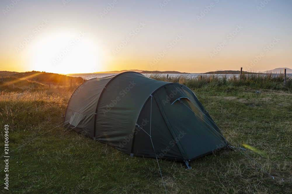 Two person tent pitched near the beach, with a beautiful sunset in the