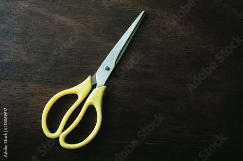 scissors on dark wooden table