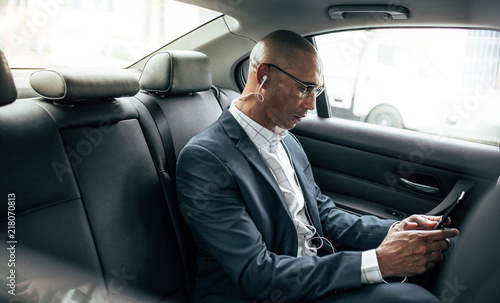 Businessman sitting in car using mobile phone © Jacob Lund
