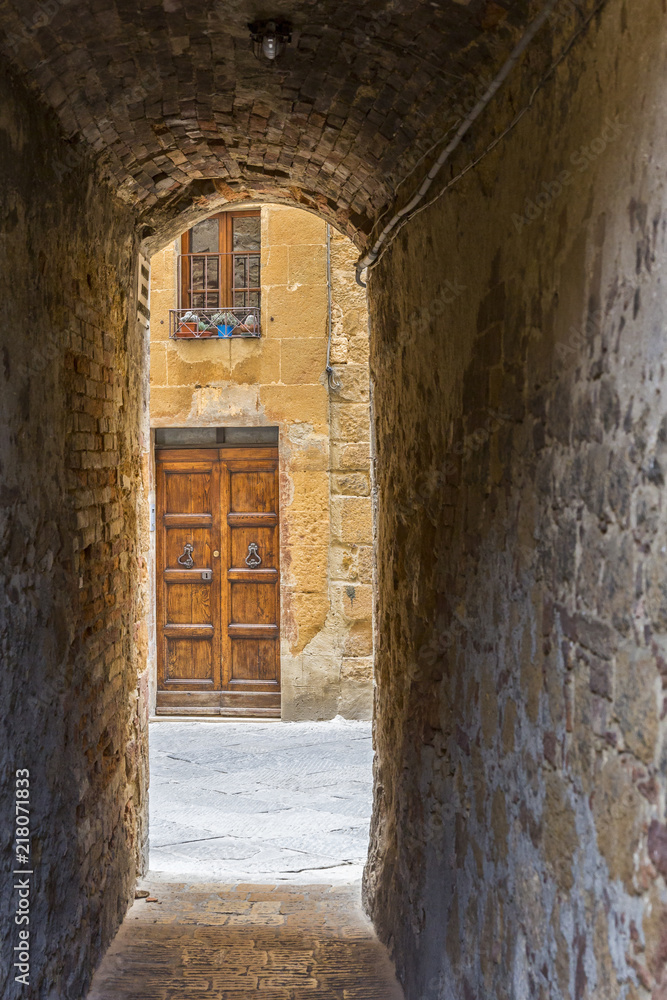 Fototapeta premium Dark narrow old alley to a street in an Italian city