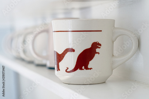 White cup with dinosaures printied on it photo