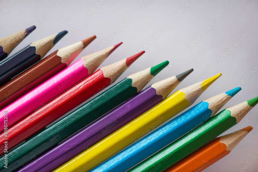 Pile of sharp coloured drawing pencils on table. Rainbow colors red, yellow, blue, green, purple. Concept of art, crafts and kids having fun Pile of sharp coloured drawing pencils on table. Rainbow colors red, yellow, blue, green, purple. Concept of art, crafts and kids having fun