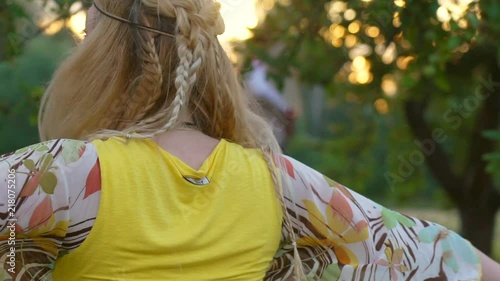 young blond hippie woman dancing on grass in park at sunset. Warm summer day and soft backlight. happy woman is dancing. the middle plan. a hot summer day. Slow motiom HD photo