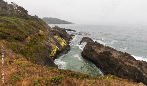 Mendoncino coast inlet with water and waves on foggy morning