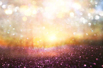 blurred abstract photo of light burst among trees and glitter golden bokeh lights.