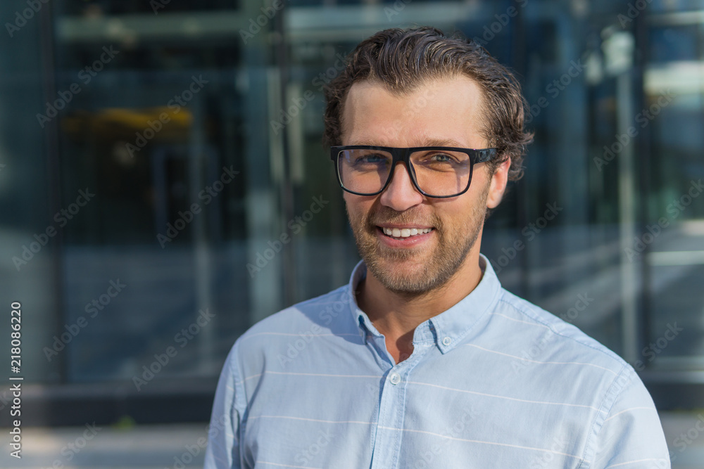 Young man in glasses smiling and looking at camera Young man in glasses smiling and looking at camera