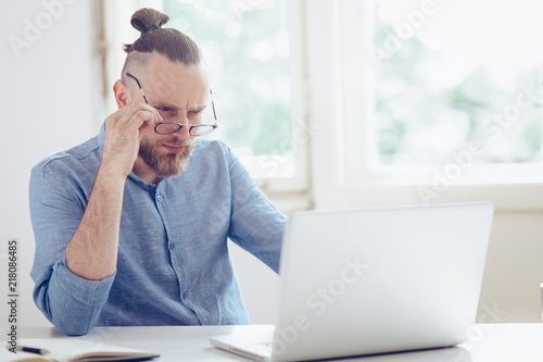 Young businessman working on laptop. Young man working on his desk.