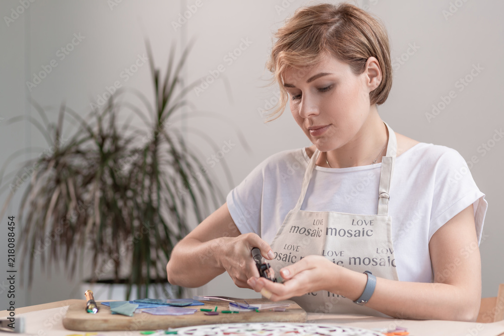 Fototapeta premium Portrait of master working on new modern colorful mosaic. Close-up