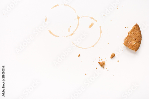 Cookie crumbs and coffee stains on white table. photo
