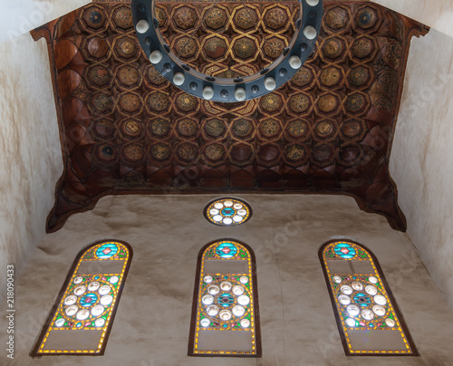 Ornate ceiling with golden floral pattern decorations and colorful stained glass windows at historic Bashtak Palace, located in Muizz Street, Gamalia district, Cairo, Egypt photo