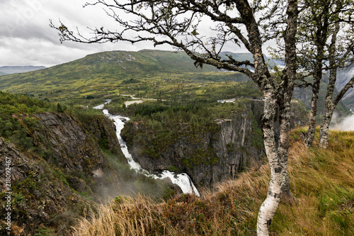 Beautiful view of the Voringsfossen waterfall. Bjoreio river . National park Hardangervidda, Eidfjord, Norway. Summer landscape in the mountains with a waterfall and fog. Foggy weather in the mountain photo