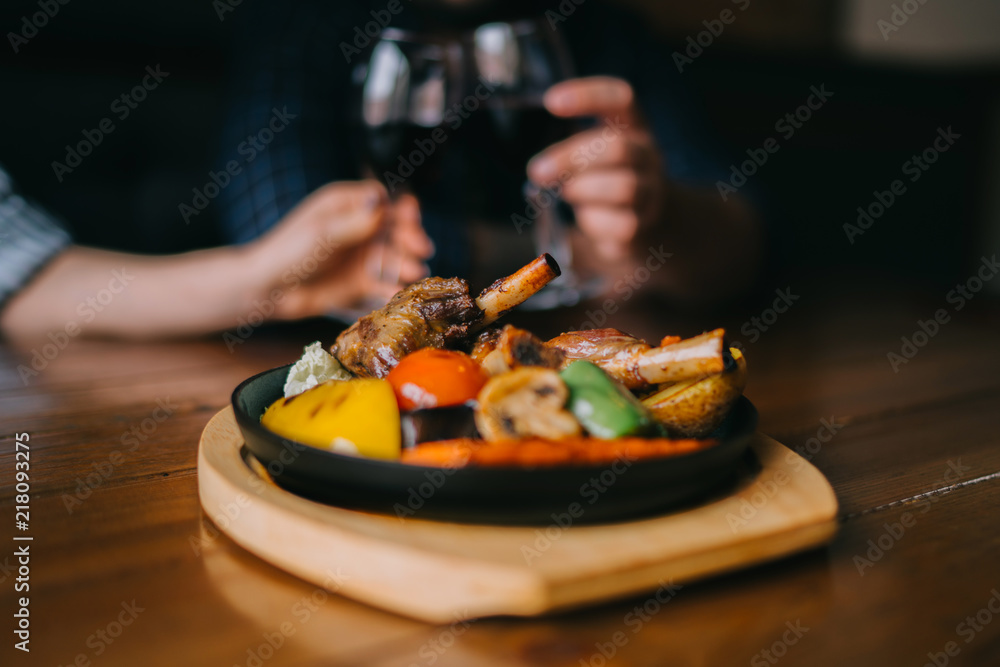 Glasses of red wine with food on table. Selective focus, blurred couple toasting with glasses of red wine in the restoran. Blurred abstract background of clinking glasses of wine. Selective focus. Glasses of red wine with food on table. Selective focus, blurred couple toasting with glasses of red wine in the restoran. Blurred abstract background of clinking glasses of wine. Selective focus.