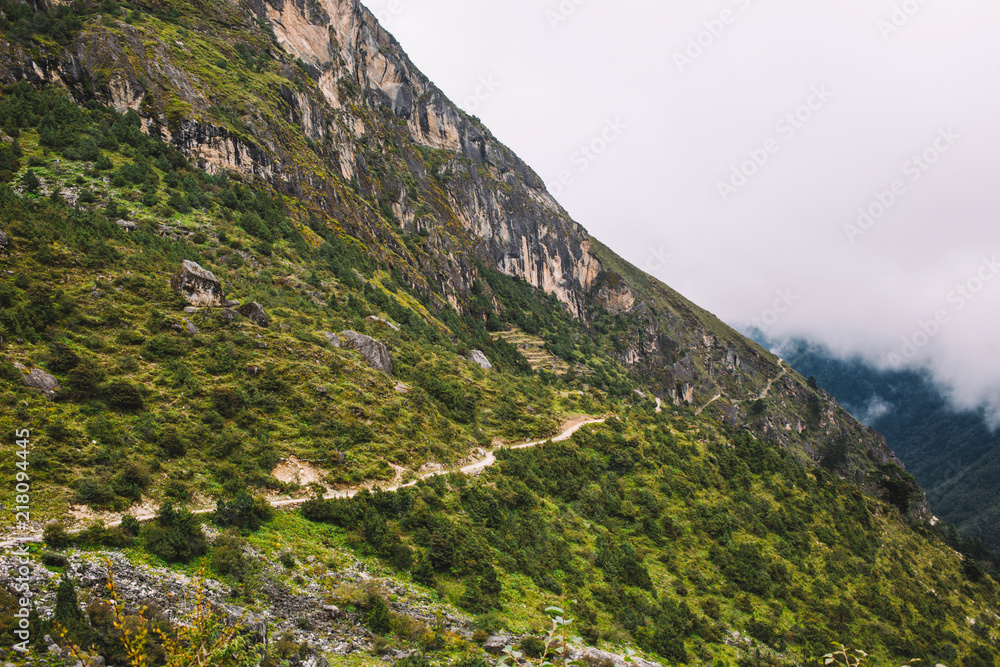 Fototapeta premium Beautiful landscape with high mountains peaks with clouds. Scenic view on the way to the Everest base camp Nepal. Mountain background. Mountain trail. Amazing scene with Himalayan mountains. Nature.