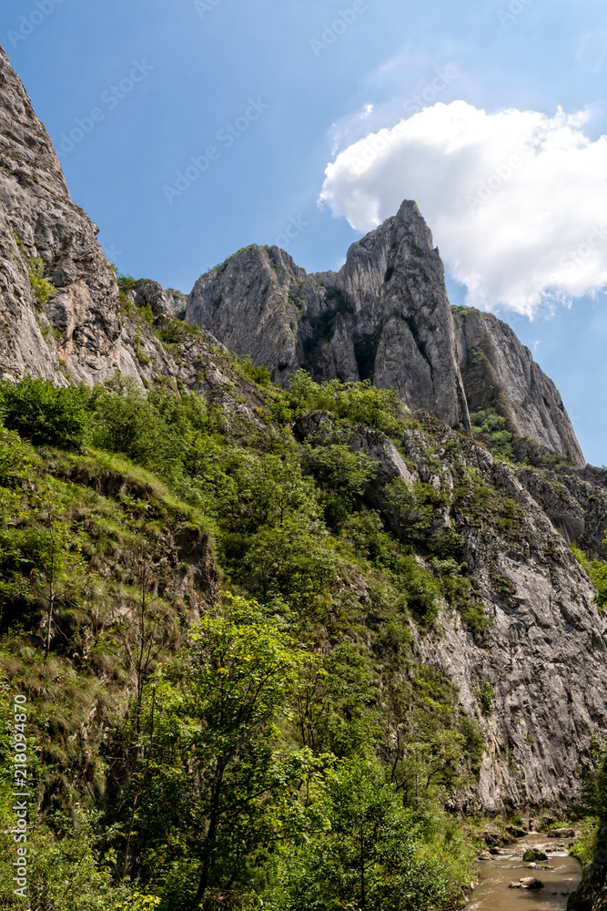Obraz premium High mountain cliff edge against blue sky with clouds