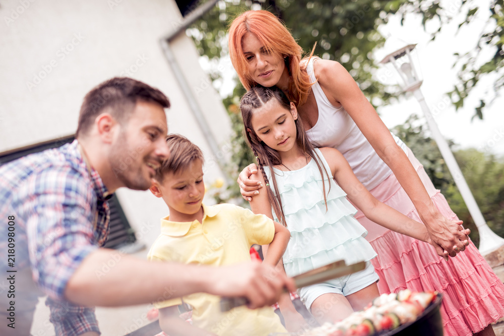 Father teaching children how to cooking meat on barbecue grill Father teaching children how to cooking meat on barbecue grill