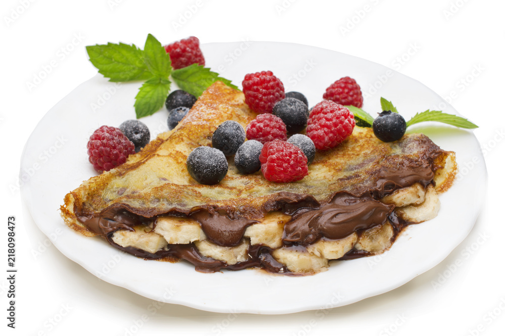 Homemade crepes served with chocolate cream, fresh blueberries and raspberries, powdered sugar on a white background Homemade crepes served with chocolate cream, fresh blueberries and raspberries, powdered sugar on a white background