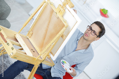 man painting on a canva at home