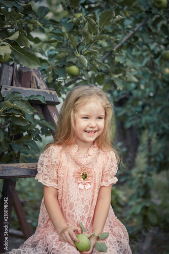Beautiful little girl in apple garden