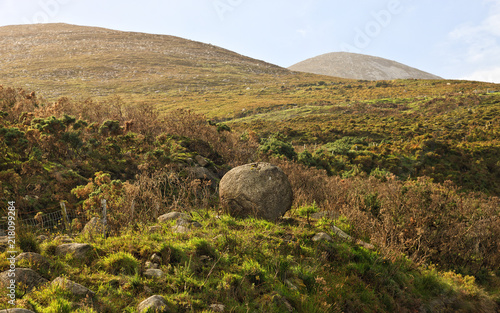 Landscape with a round stone in the Mourne Mountains, near Newcastle, Northern Ireland. Landscape, historical place, tourist route.