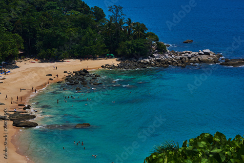 Tropical white sandy beach with rocky mountains and clear water of Indian ocean. View of turquoise bay with rocks with lush tropical forest. Clear water of the lagoon. Turquoise water background.