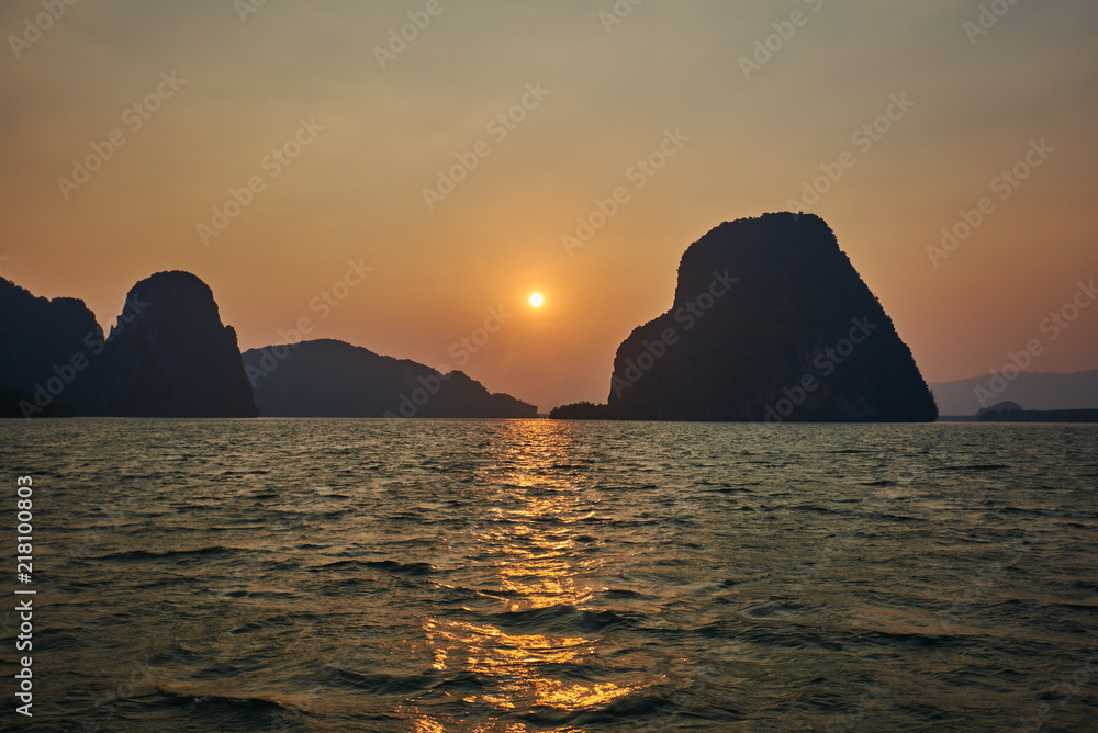 Romantic bay sunset over limestone rocks in sea. Beautiful tropical landscape. Travel lifestyle. Wild nature vacations. Adventure ecotourism concept.