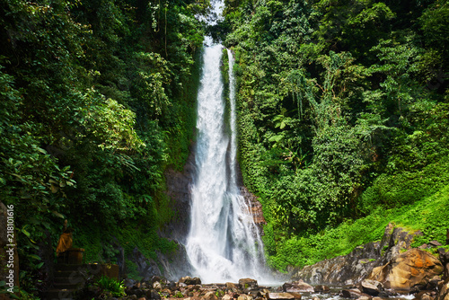 Fototapeta Naklejka Na Ścianę i Meble -  Beautiful waterfall in green tropical forest. View of the falling water with splash of water makes. Nature landscape. Morning view on hidden majestic waterfall in the deep rain forest jungle. .
