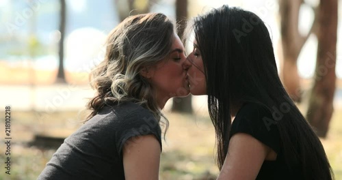 Lesbian cuple kissing each. LGBT Girlfriend kisses female mate at the park3
