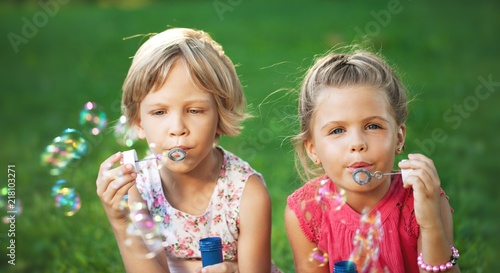 Portrait of Two Little Girlfriends / Sisters Blowing Bubbles