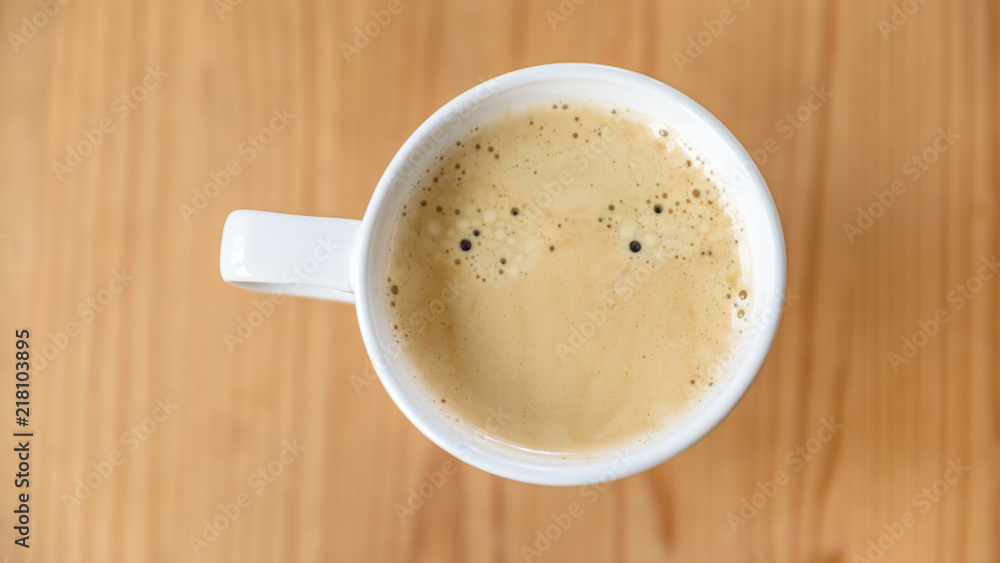 Weiße Kaffeetasse mit Kaffe - Flat Lay auf Holztisch Weiße Kaffeetasse mit Kaffe - Flat Lay auf Holztisch