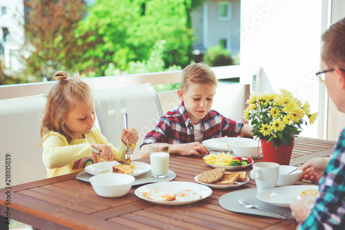 Happy young family having fun during breakfast on terrasse at home © spass