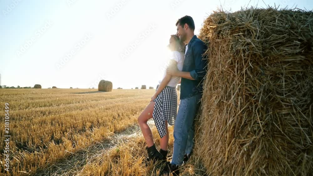 Side view of Joyful lovely hipster couple standing together near the hay bale on field
Side view of Joyful lovely hipster couple standing together near the hay bale on field
