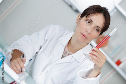 professional doctor is making notes on blood sample