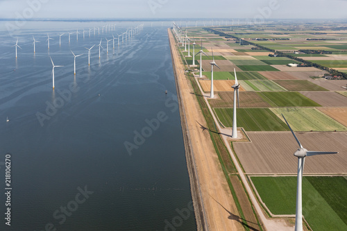 Aerial view Dutch agricultural landscape with big offshore wind turbines along the coast